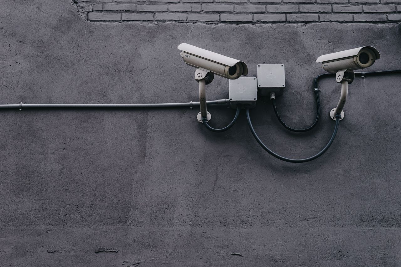 Home Two surveillance cameras mounted on a concrete wall, highlighting security technology.